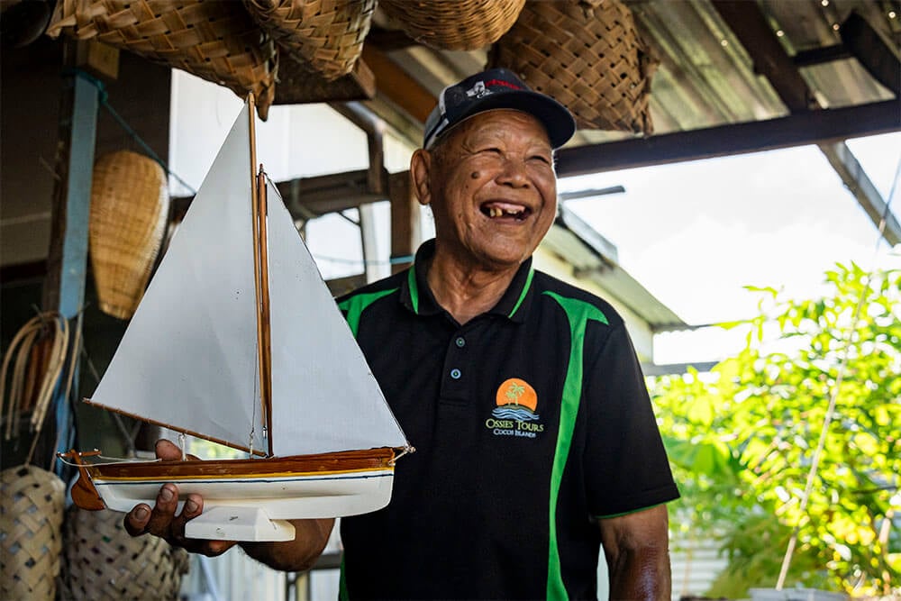 A Home Island local displays a handcrafted boat